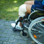 Close-up of male moving on wheelchair in park